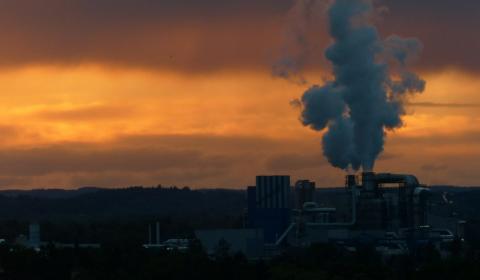 Vue au coucher du soleil des nuages de fumée sortant des cheminées d'une usine
